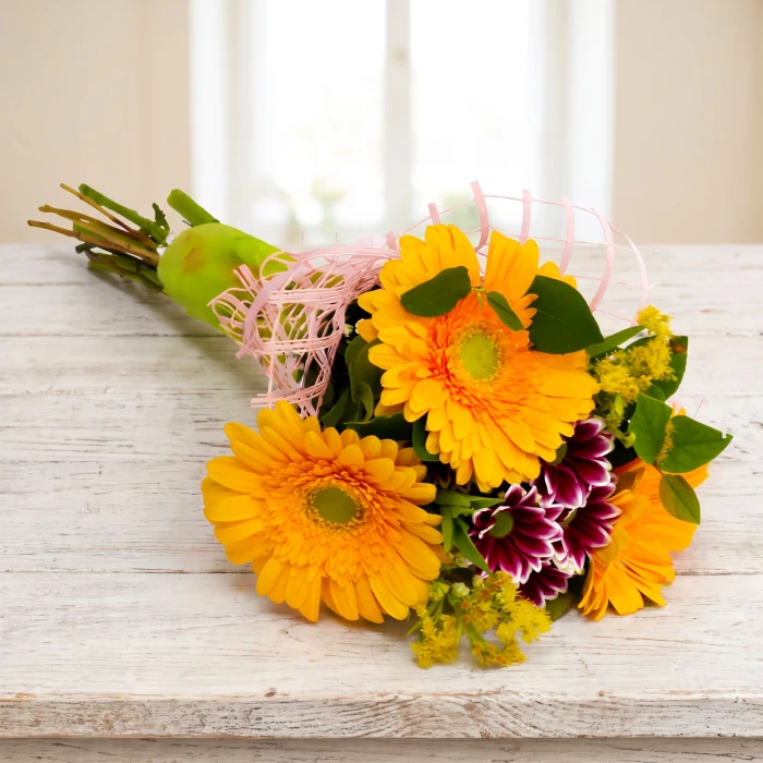 A bouquet of yellow gerberas and greenery.