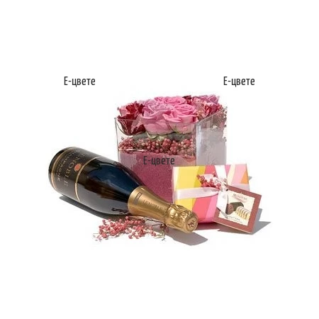 Flower arrangement of pink roses, chocolates and sparkling wine